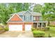 Charming two-story home featuring a brick facade, three-car garage, and a beautifully landscaped front yard at 3016 Levinshire Way, Dacula, GA 30019