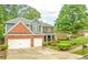 Well-maintained two-story home showcasing brick and siding exterior, a three-car garage, and manicured landscaping at 3016 Levinshire Way, Dacula, GA 30019