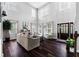 Bright living room with soaring ceilings, hardwood floors, and a cozy seating area, and dark-stained entryway door at 3016 Levinshire Way, Dacula, GA 30019
