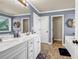 Bathroom featuring double sinks, white cabinets, and a separate bathtub at 2102 Braswell Ln, Loganville, GA 30052