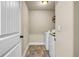 Functional laundry room featuring tile flooring, a washer, a dryer, and storage shelves at 2102 Braswell Ln, Loganville, GA 30052