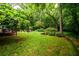 Expansive backyard featuring lush lawn, mature trees, and outdoor living area with grill at 2804 Dunnington Cir, Chamblee, GA 30341