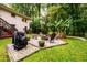Backyard with patio seating area and fire pit, surrounded by lush landscaping and mature trees at 2804 Dunnington Cir, Chamblee, GA 30341