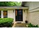 Close-up of the front door showcasing its unique design, flanked by sconces and complemented by the surrounding brickwork at 2804 Dunnington Cir, Chamblee, GA 30341