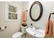 Well-lit half bathroom with a stylish oval mirror, sleek faucet, and a window providing natural light at 2804 Dunnington Cir, Chamblee, GA 30341