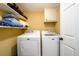 Functional laundry room with washer, dryer, and storage shelves at 2804 Dunnington Cir, Chamblee, GA 30341
