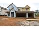 Two-story home under construction featuring a two-car garage and covered porch awaiting its finishing touches at 452 Maypop Ln, Woodstock, GA 30188
