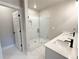 Bright bathroom featuring double sinks, a glass enclosed shower with marble-style tile, and an open doorway at 5704 Urban Village Way # 3, Tucker, GA 30084