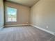 Carpeted bedroom with a window offering natural light, neutral walls and trim at 5704 Urban Village Way # 3, Tucker, GA 30084