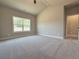 Bright bedroom featuring plush carpeting, neutral walls, a large window, and access door at 5704 Urban Village Way # 3, Tucker, GA 30084