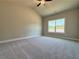 Spacious bedroom featuring neutral walls, plush carpeting, a large window, and vaulted ceiling with fan at 5704 Urban Village Way # 3, Tucker, GA 30084
