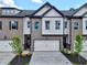 New construction townhome with brick and siding, featuring a two-car garage and manicured landscaping at 5704 Urban Village Way # 3, Tucker, GA 30084