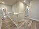Upstairs hallway featuring a light-colored wall and neutral-toned floors, with a view into a bathroom at 5704 Urban Village Way # 3, Tucker, GA 30084