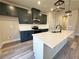 Modern kitchen with dark cabinets, stainless steel appliances, and a large island with a white countertop at 5704 Urban Village Way # 3, Tucker, GA 30084