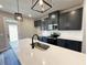 Well-lit kitchen showcasing dark cabinets, stainless steel appliances, and a large island with a modern faucet at 5704 Urban Village Way # 3, Tucker, GA 30084