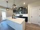 Stylish kitchen with dark cabinetry, stainless steel appliances, a large island, and modern pendant lighting at 5704 Urban Village Way # 3, Tucker, GA 30084