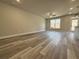 Expansive living room with hardwood floors, a ceiling fan, and ample natural light, leading to a backyard at 5704 Urban Village Way # 3, Tucker, GA 30084
