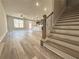 Open-concept living space with hardwood floors, staircase, and a modern kitchen in the background at 5704 Urban Village Way # 3, Tucker, GA 30084