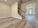 Spacious living room with hardwood floors, staircase, and neutral paint, leading to front door at 5704 Urban Village Way # 3, Tucker, GA 30084