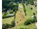 Aerial view of a sprawling property with lush greenery, a tennis court, and long private driveway at 3030 Berry Rd, Loganville, GA 30052