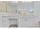 Bathroom vanity with marble countertop, gold faucet, decorative mirror, and ample storage space at 3030 Berry Rd, Loganville, GA 30052