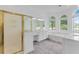 Bright bathroom featuring wood tile floors, garden tub, gold-trimmed shower, and double vanity sinks at 3030 Berry Rd, Loganville, GA 30052