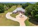 Aerial view of a well-maintained home with a circular driveway, manicured lawn, and mature landscaping at 3030 Berry Rd, Loganville, GA 30052