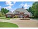 Attractive brick home with a circular driveway, elegant landscaping, and a well-manicured lawn at 3030 Berry Rd, Loganville, GA 30052