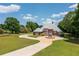 Wide angle view of a grand brick home featuring a circular driveway, fountain, and a lush green lawn at 3030 Berry Rd, Loganville, GA 30052
