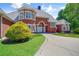 Charming brick home showcasing a circular driveway, verdant landscaping, and an immaculate lawn at 3030 Berry Rd, Loganville, GA 30052
