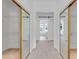 Hallway leading to a bright bathroom with mirrored closet doors, featuring ample storage and natural light at 3030 Berry Rd, Loganville, GA 30052