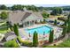 Aerial view of a community pool, featuring lounge chairs, tables with umbrellas and mature landscaping at 329 Acuba Vw, Woodstock, GA 30188