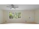 Bright living room featuring new flooring, a ceiling fan, and a large window that offers natural light at 8432 Magnolia Dr, Jonesboro, GA 30238