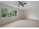 Open living room with sleek flooring, a ceiling fan, and a large window that offers natural light at 8432 Magnolia Dr, Jonesboro, GA 30238