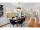 Dining room with modern light fixture, hardwood floors, view to the living room and access to kitchen at 1721 S Gordon Sw St, Atlanta, GA 30310