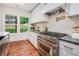 Chef's kitchen with stainless steel range, modern hood, white cabinetry and view to the backyard at 1721 S Gordon Sw St, Atlanta, GA 30310