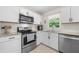 Bright kitchen with white cabinets, subway tile backsplash, granite countertops, and stainless steel appliances at 3770 Ponderosa Ln, Powder Springs, GA 30127