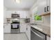 Well-lit kitchen featuring white cabinets, stainless steel appliances, granite countertops, and a view of the backyard at 3770 Ponderosa Ln, Powder Springs, GA 30127