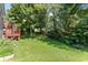 Large, grassy backyard with a wooden deck and a wooded area beyond the lawn at 4303 Anderson Ridge Dr, Austell, GA 30106