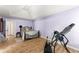Bright bedroom featuring light purple walls, wood floor and large exercise machine at 4303 Anderson Ridge Dr, Austell, GA 30106