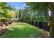 Spacious backyard featuring manicured lawn and privacy fence with mature trees at 4495 Westgate Dr, Cumming, GA 30040