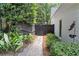 Private backyard walkway lined with lush greenery and leading to a wooden gate at 4495 Westgate Dr, Cumming, GA 30040