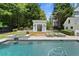 Stunning pool area with hot tub and pool house set amidst lush greenery for ultimate relaxation and privacy at 4495 Westgate Dr, Cumming, GA 30040