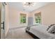 Stylish bedroom with neutral walls, modern lighting and large windows with wooded view at 4495 Westgate Dr, Cumming, GA 30040