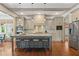 Modern kitchen featuring a central island with seating, stainless steel appliances, and hardwood floors at 4495 Westgate Dr, Cumming, GA 30040