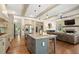 Spacious eat-in kitchen with stainless appliances flows into the living room with stone fireplace and coffered ceiling at 4495 Westgate Dr, Cumming, GA 30040