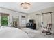 Light and airy main bedroom with a modern chandelier and a sliding barn door to the bathroom at 4495 Westgate Dr, Cumming, GA 30040