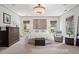A bright main bedroom featuring a crystal chandelier, a seating area, and neutral decor at 4495 Westgate Dr, Cumming, GA 30040
