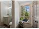 Powder room with a large window overlooking the trees and a granite vanity at 4495 Westgate Dr, Cumming, GA 30040