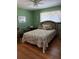 Comfortable bedroom offers hardwood floors, a ceiling fan, and a cozy floral comforter at 4961 Ivey Road, Acworth, GA 30101